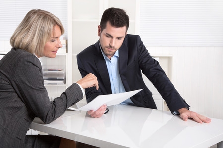 Young man and woman at work looking at document