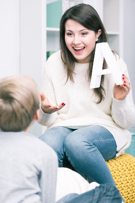 Smiling young therapist with child